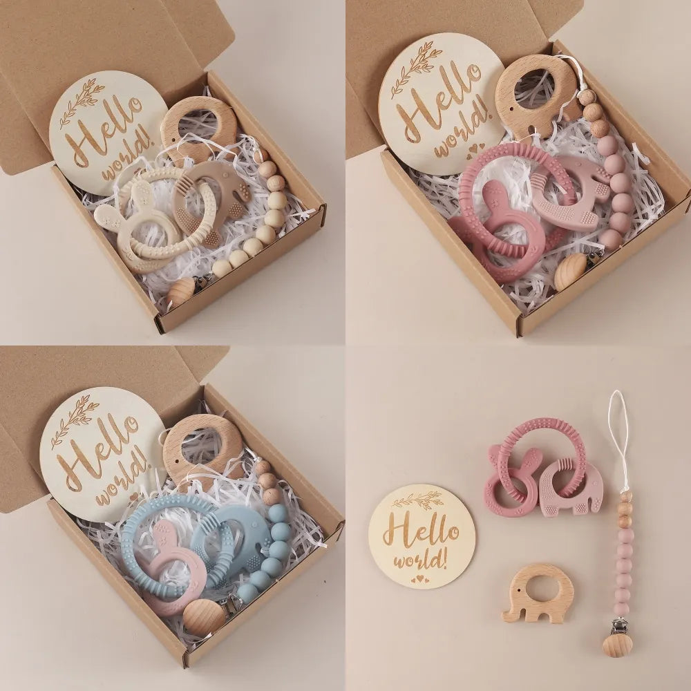 Baby teething toys with 'Hello world!' sign in a cardboard box on a light background