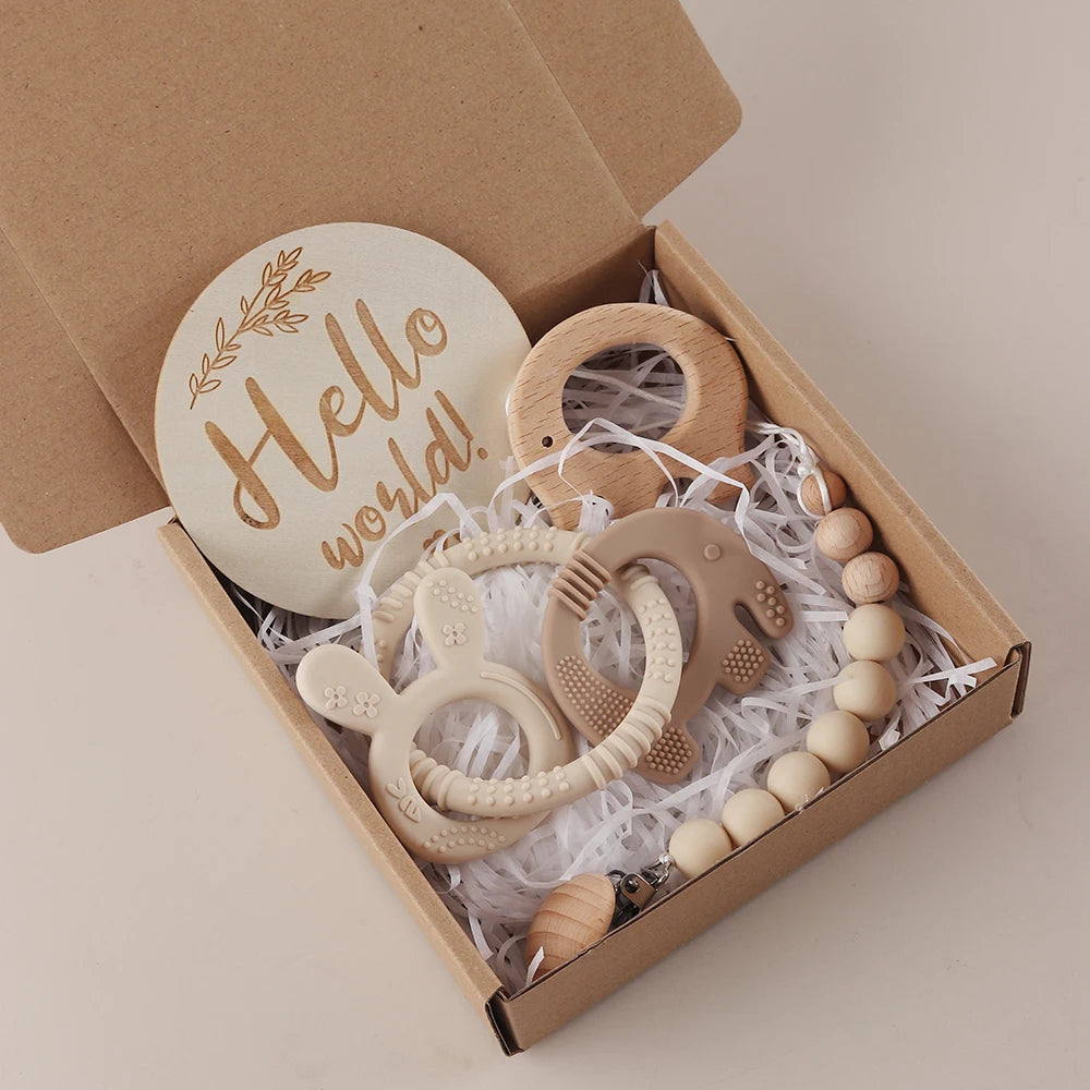 Set of wooden baby teething rings and beads in a box with 'Hello world!' sign.